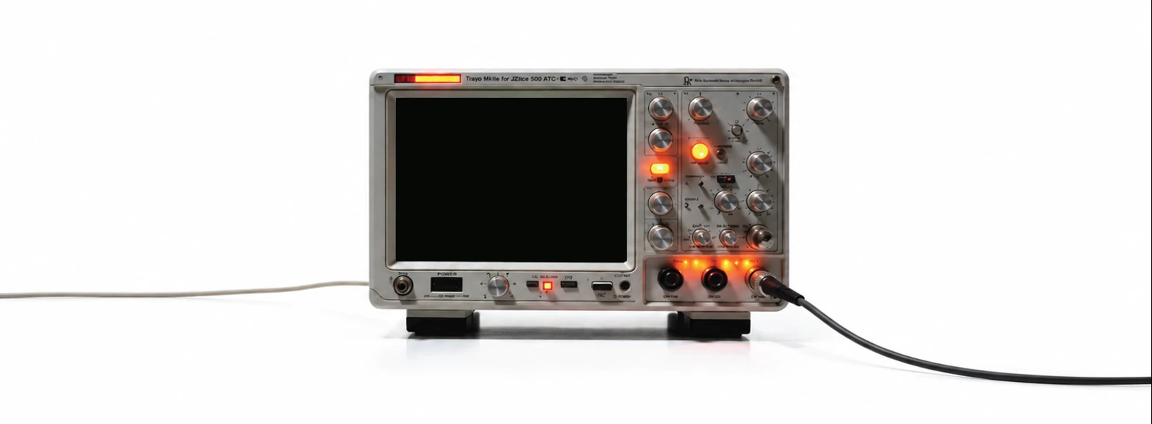 A benchtop oscilloscope on a white surface, its screen lit green.